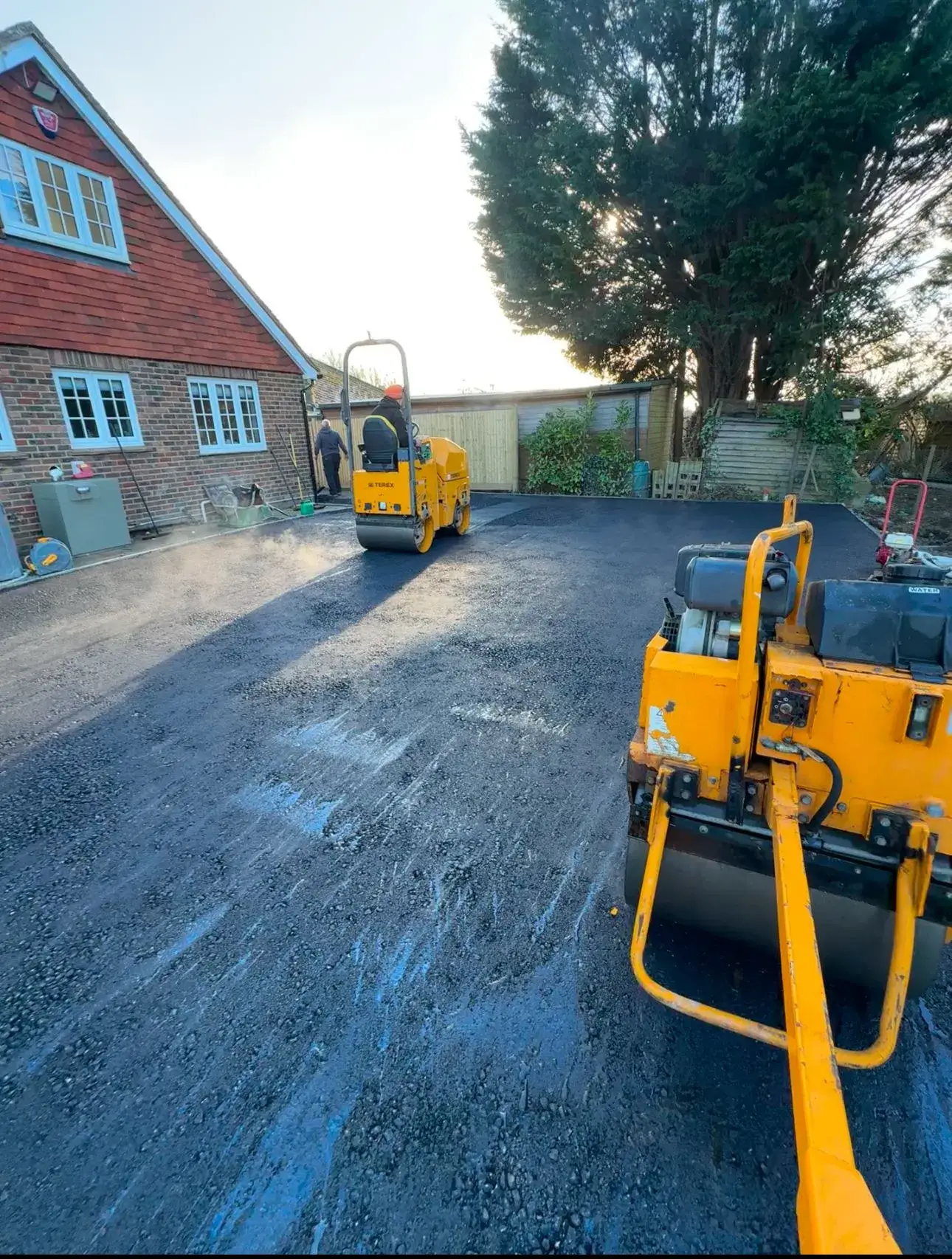 Yellow diggers tarmacing the road